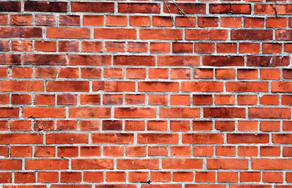  Rød murstensvæg med lyse fuger der skal udskiftes