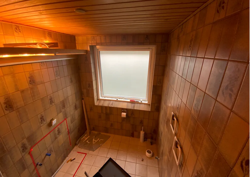 Et tidstypisk badeværelse fra 80serne med orange mursten og plastic tilbehør